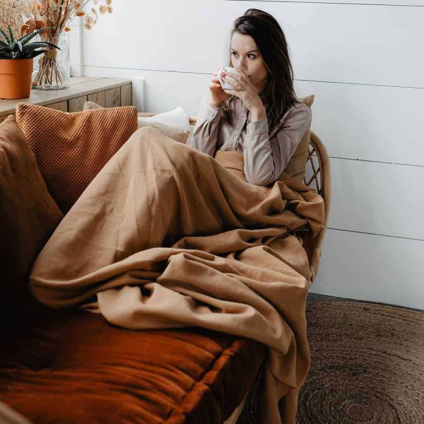 ValerieVisschedijk-Jannekeswarmtesjaal-64 Plaid camel ontspannen vrouw op de bank met warme drank.