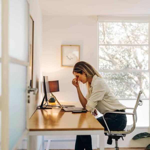 exhausted businesswoman having a headache in her office exhausted businesswoman having a headache in her office