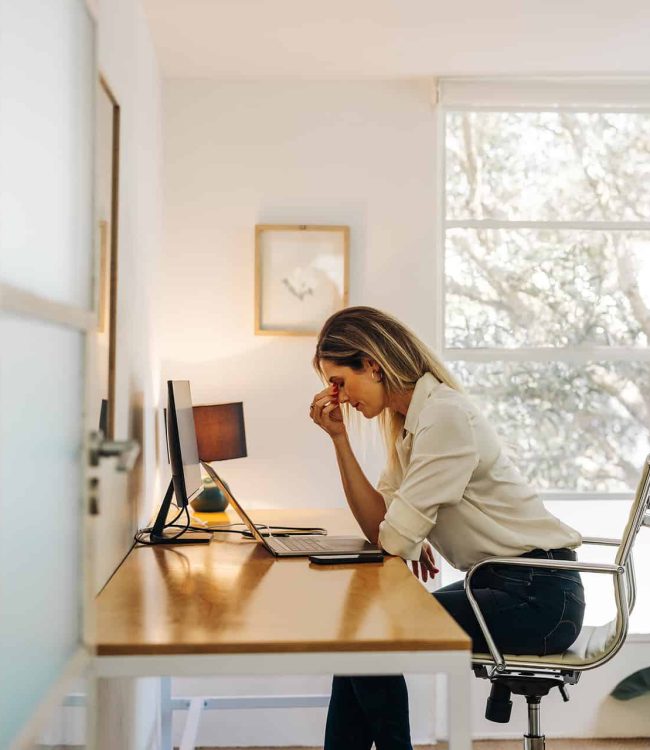 exhausted businesswoman having a headache in her office exhausted businesswoman having a headache in her office