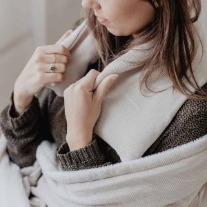 Close up foto van een jonge vrouw gewikkeld in een warme plaid en een warmtesjaal over haar schouders